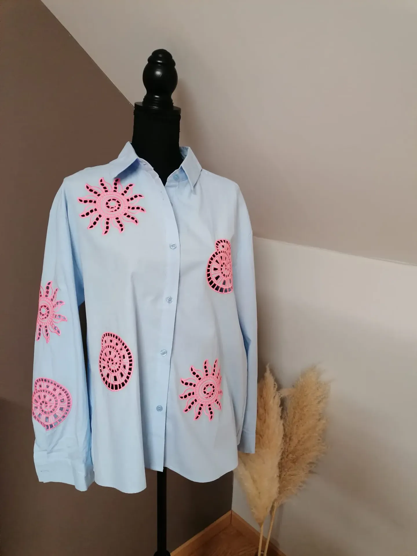 Lichtblauw hemd afgewerkt met felroze cut-out details